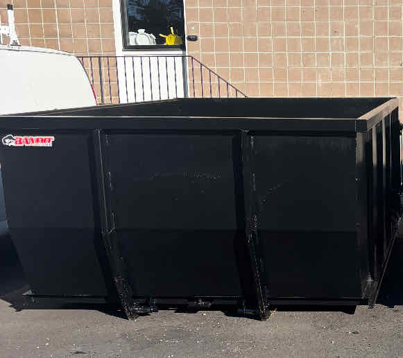 15-yard black roll-off dumpster parked in a driveway