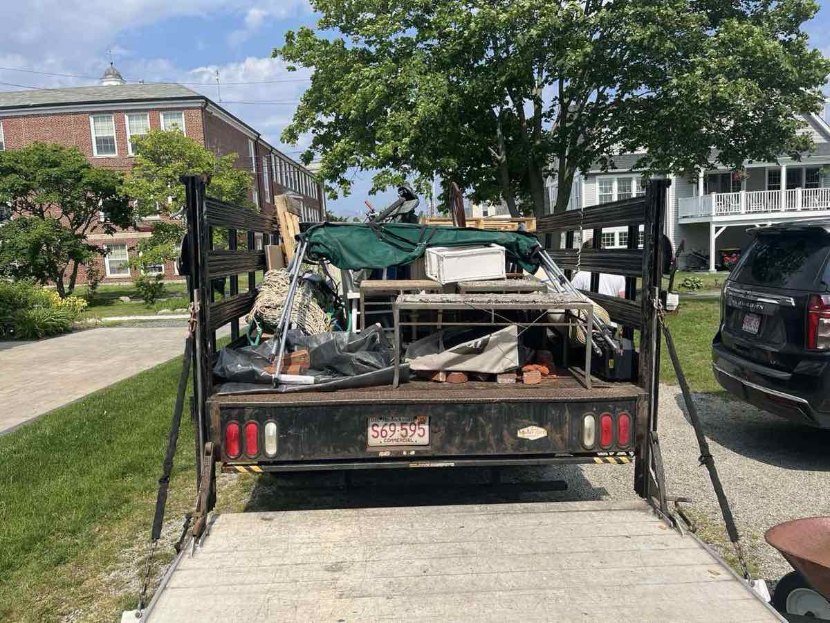 Trailer loaded with patio furniture, paint cans, and household items after a South Shore pickup