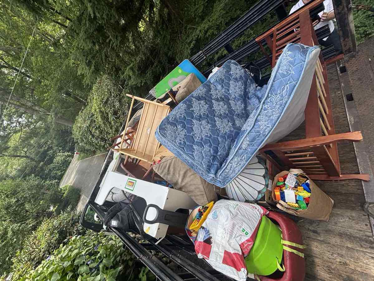 Overhead view of a trailer loaded with a mattress, furniture, and household items