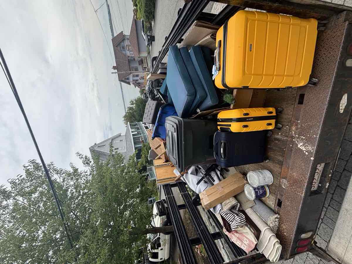 Loaded trailer with furniture and boxes, coastal Scituate-area homes and water visible in the background