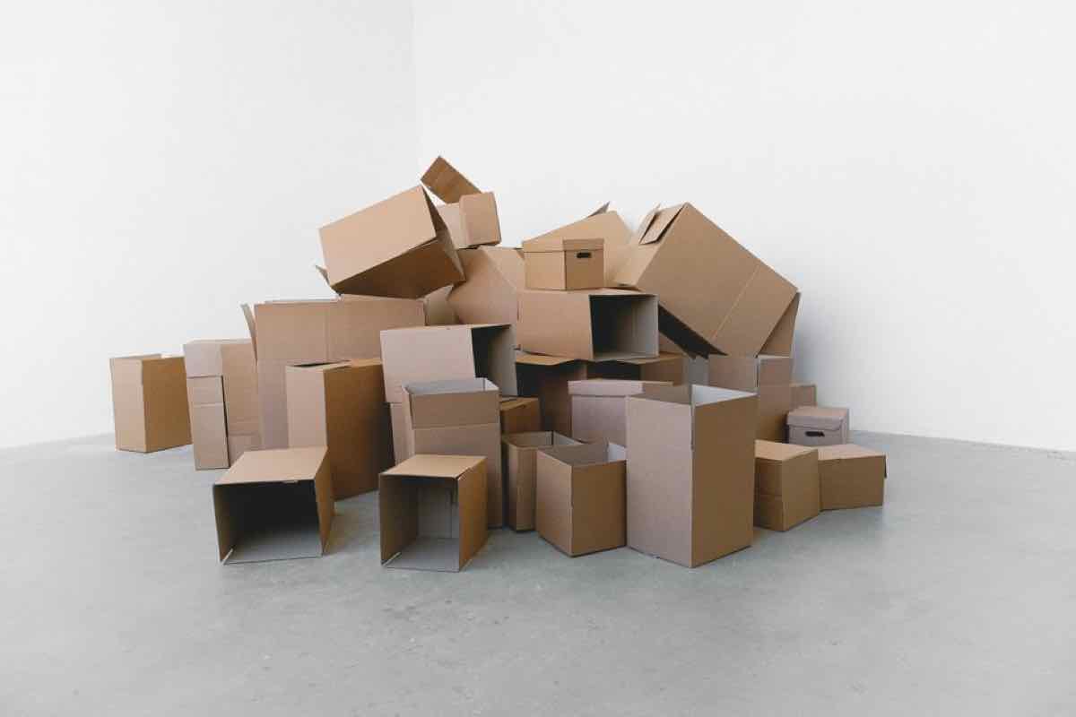 Large pile of cardboard boxes stacked in an empty room during an office cleanout