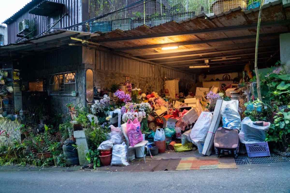 Overflowing garage storage spilling out into a driveway, packed with boxes and household items